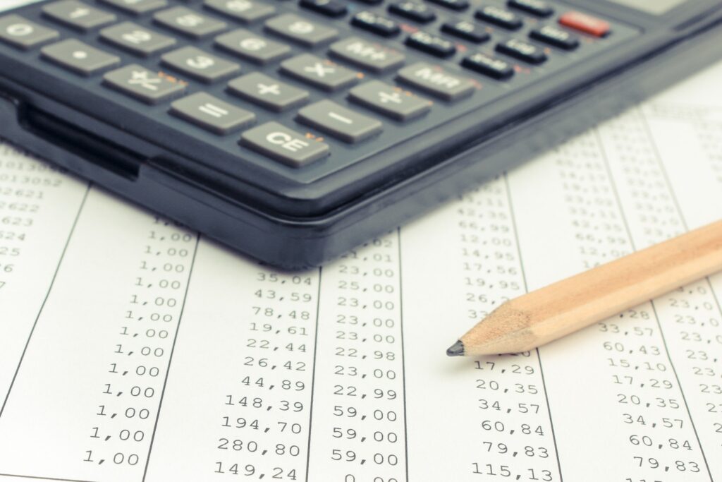 Calculator and pencil on spreadsheet. Business concept